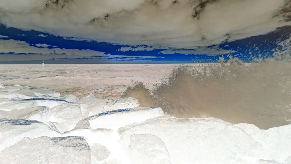 During a rough tide after the sun has set, waves crash against rocks on the shore at Carrum Beach. A colour inversion filter has been applied.